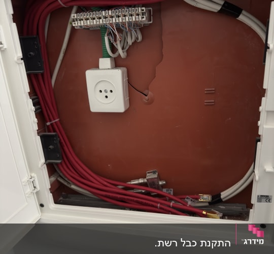 ארון תקשורת עם כבלים אדומים ולבנים מחוברים